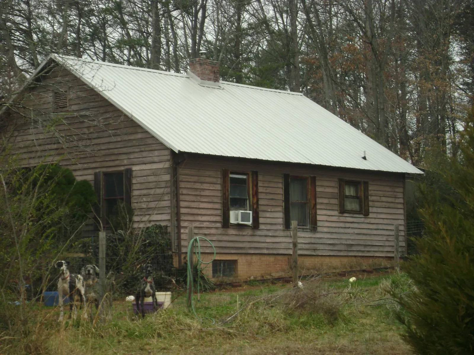 White metal roof on an old wood sided farmhouse, from a Metal Roof Installation job in Dallas